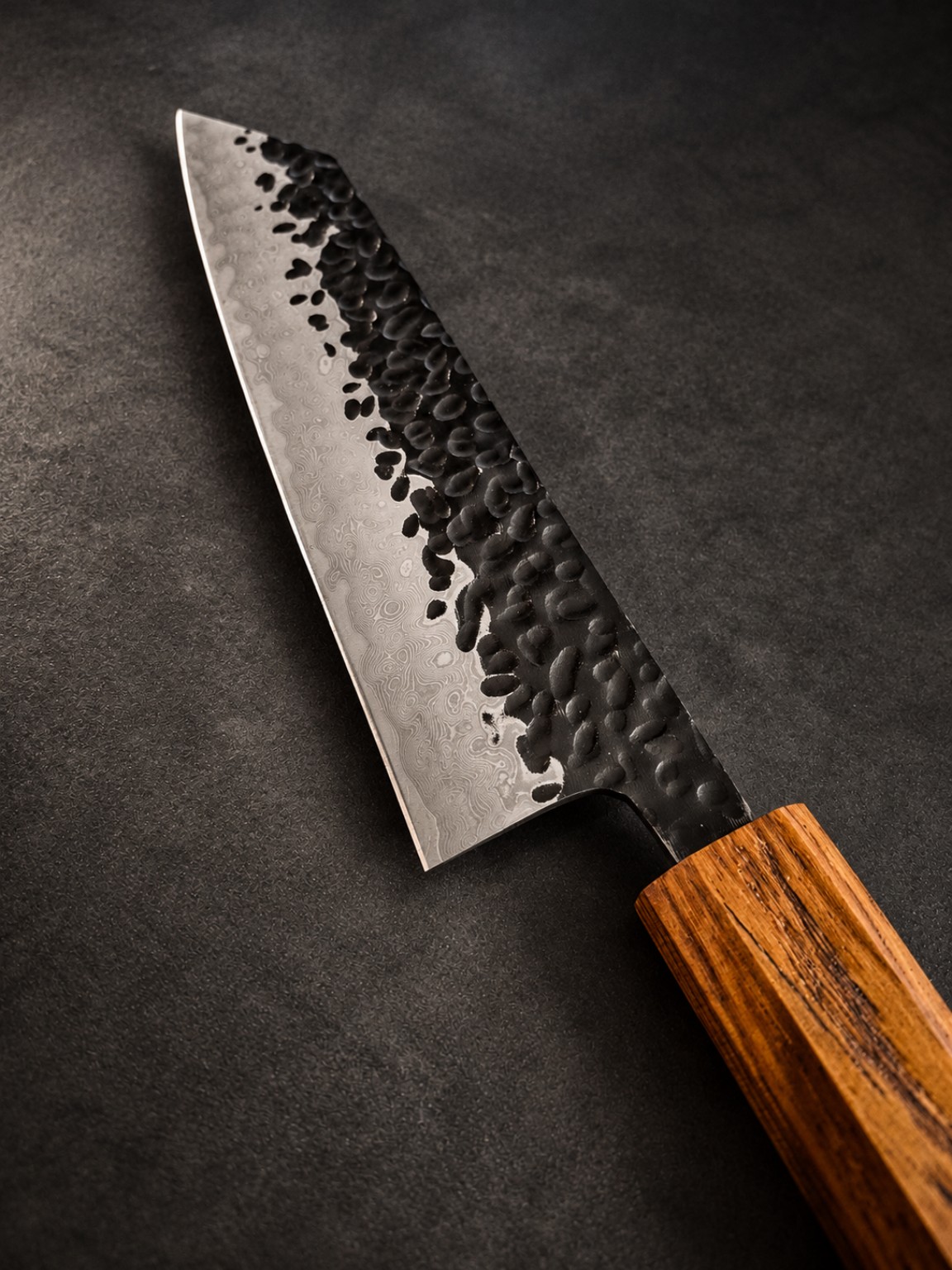 Detail of Japanese-inspired Kiritsuke Bunka blade with tsuchime hammered finish and Damascus steel pattern