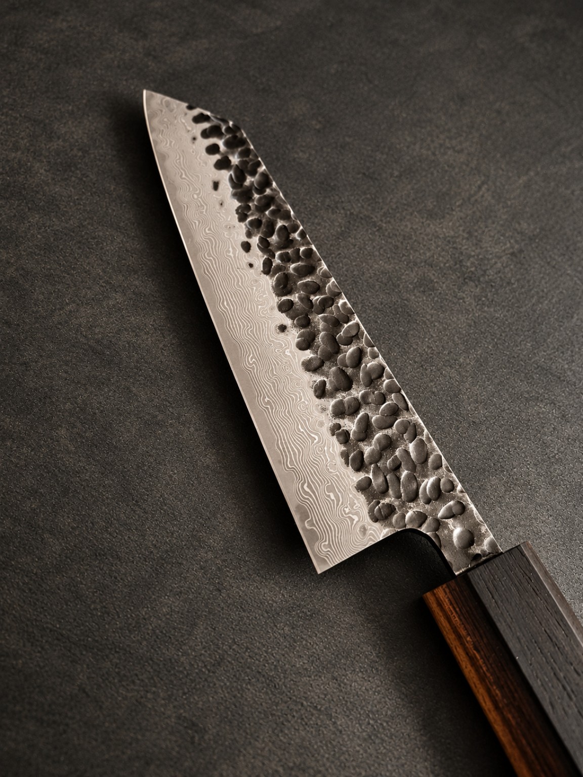 Close-up of the knife blade, showing hammered texture and a flowing layered steel pattern